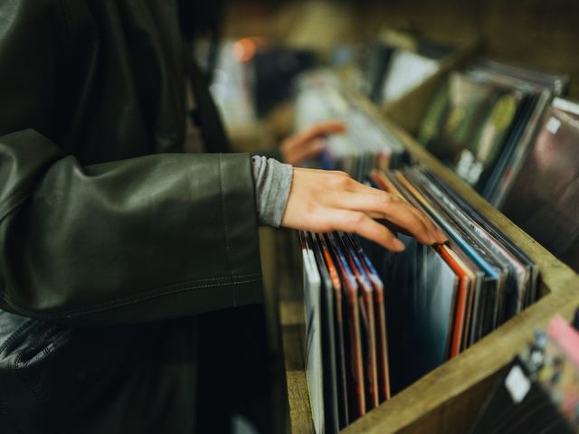 Hands flipping through a crate of LP records