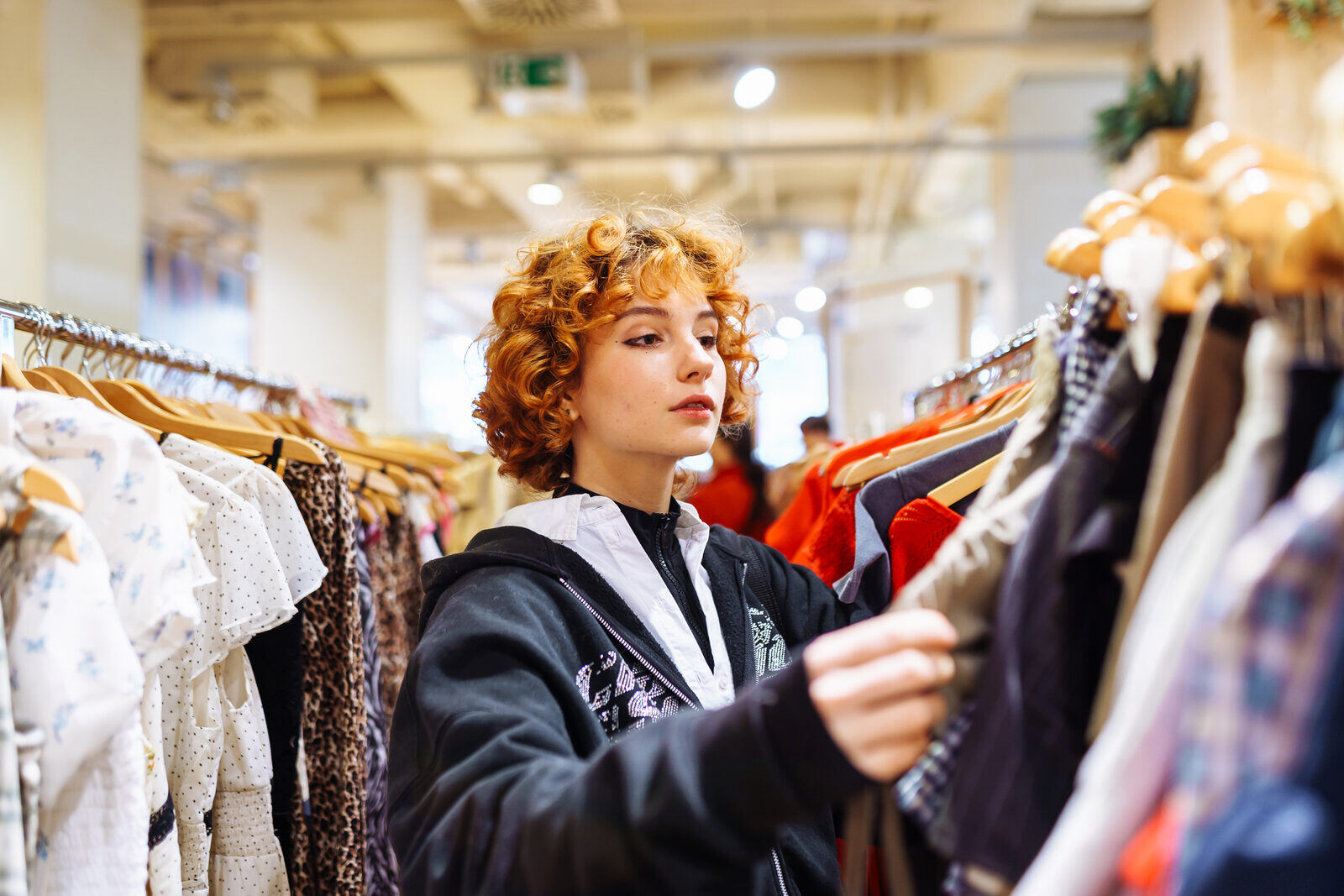 Shopper browsing a clothing rack on the sales floor